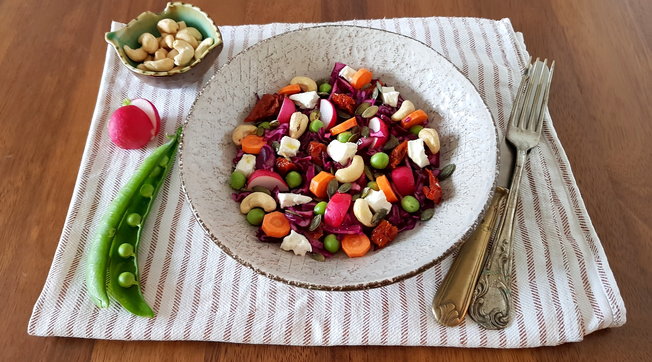 Insalata con frutta secca, feta, piselli freschi e vinaigrette all'aceto di mele